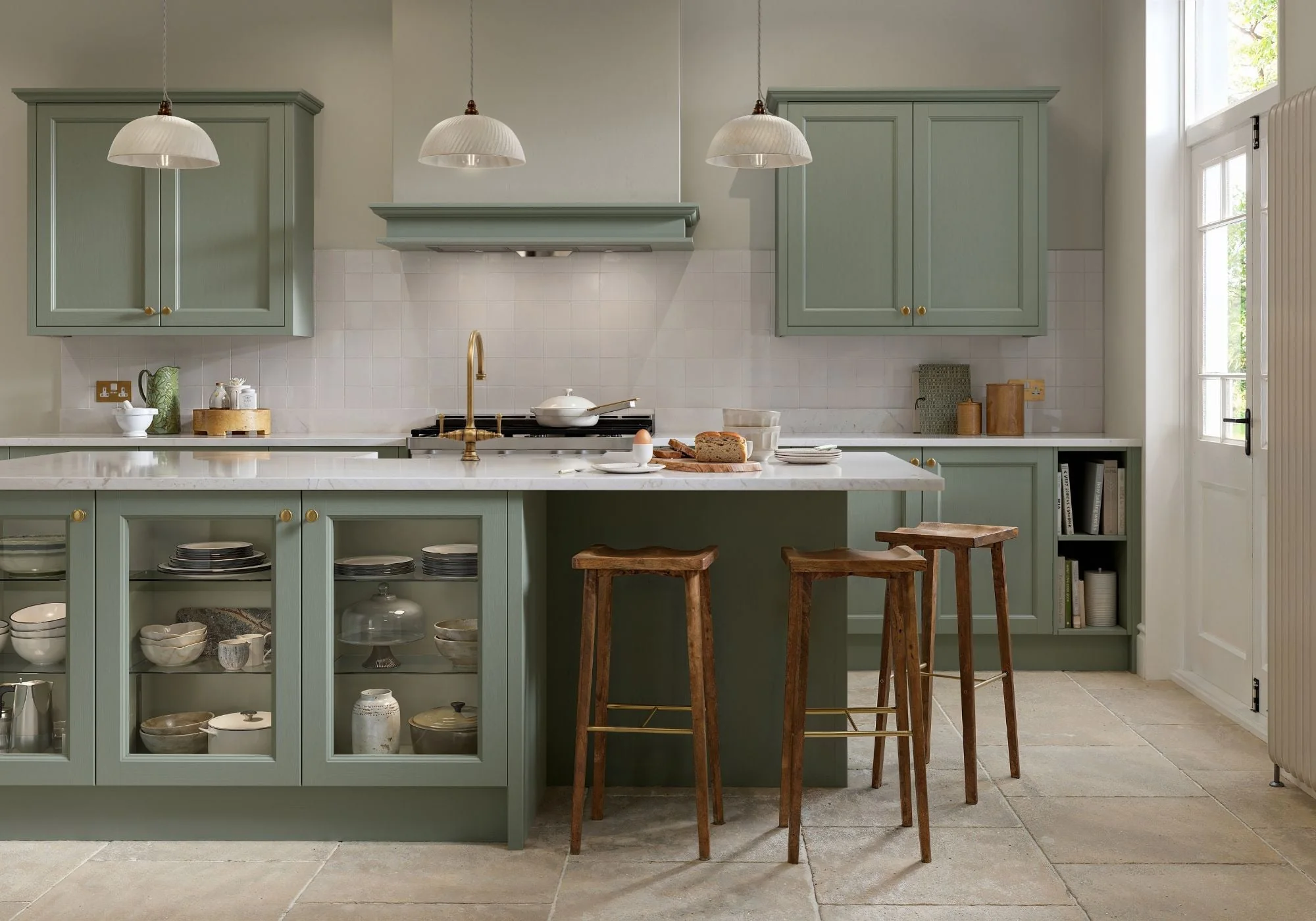 Reed green beaded shaker kitchen with a glazed island, brass fittings and timber stools