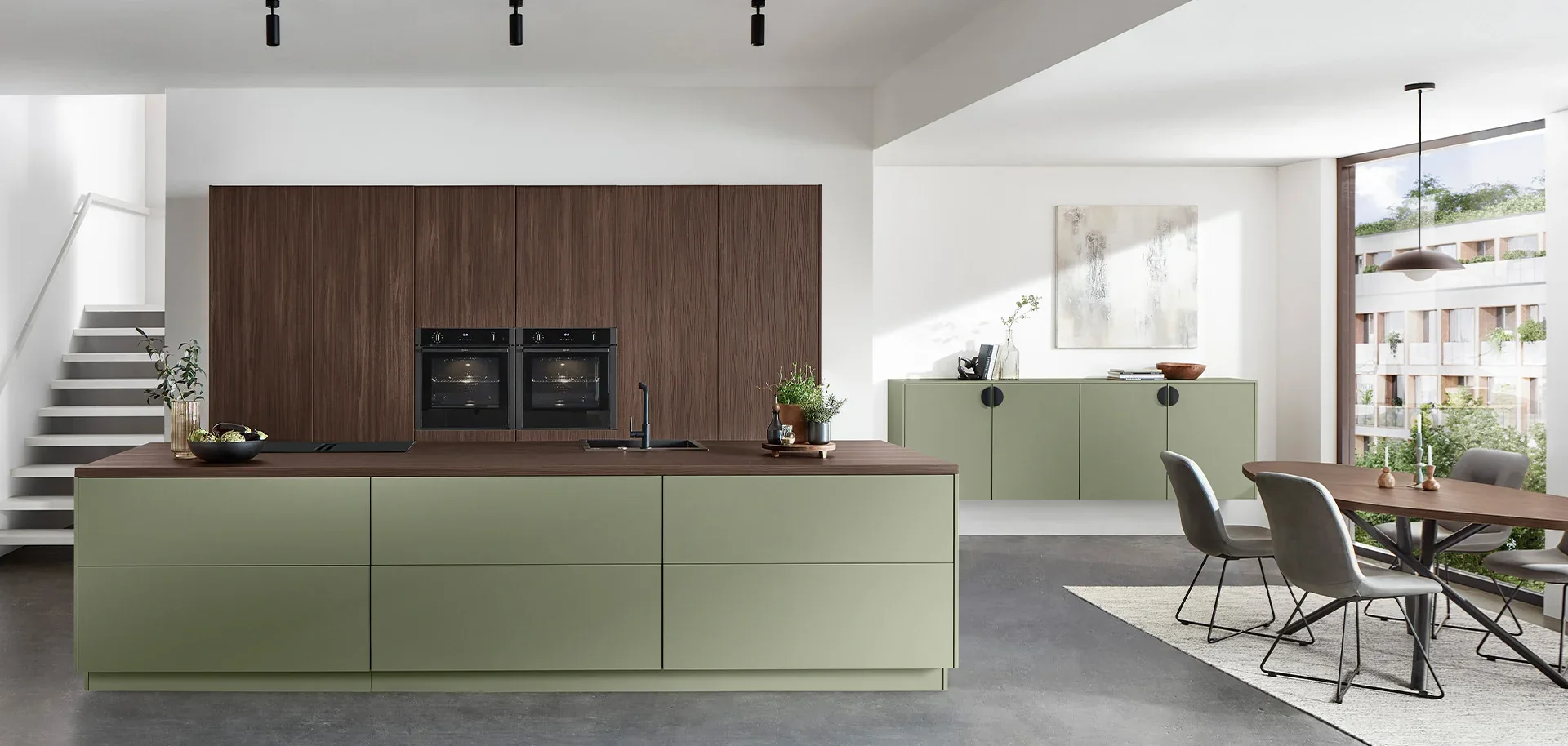 Contemporary kitchen with walnut cabinetry, muted green island and integrated storage